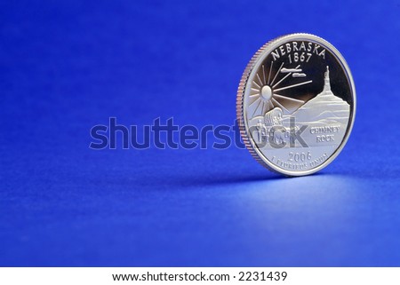2006 Nebraska State Quarter - reverse side (side with the Nebraska information, not the head). Blue background, reflection in the foreground. Space for text or graphics to the left.