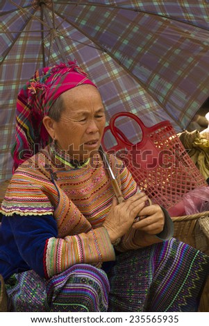 Bac Ha, Vietnam - 17 June 2013 : A flower Hmong women under an umbrella at Bac Ha Week end market, North Vietnam.
