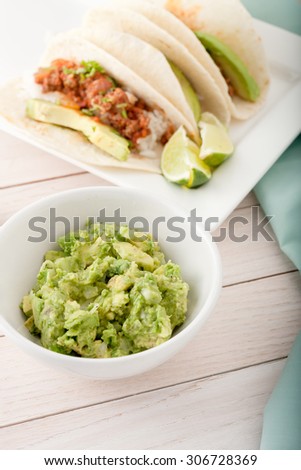 three homemade soft tacos with ground meat, avocados, cilantro and rice isolated on white background, room for text
