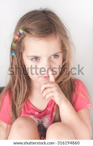 a portrait of a little girl picking her nose, isolated