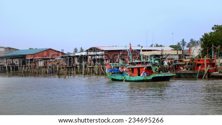 Kuala Selangor,Malaysia - June 15, 2013: fishing boat going back to seaport after catching from the ocean,and the fisherman busy with their work to uploading their catching.