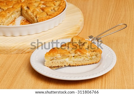 Piece of homemade pie with apples and pears on wooden table
