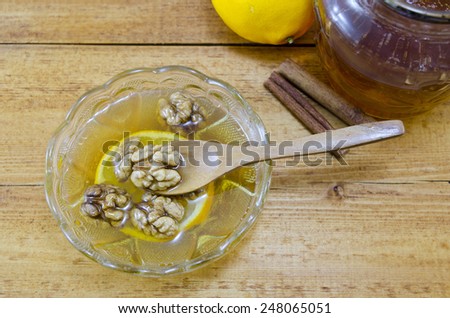 Very healthy dessert composed out of: honey, lemons, cinnamon and walnuts on a table