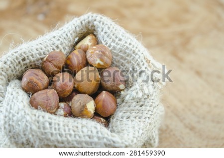 Bunch of Hazelnuts in a vintage bag on a wooden table