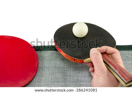 Male hand holding a ping pong racket and a table tennis ball above a net, isolated on white