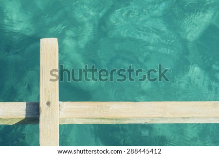 Abstract photo of a wooden board angainst clear sea water