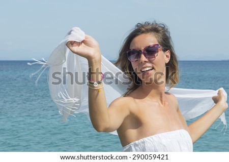 Girl vearing white dress and white scarf at sea