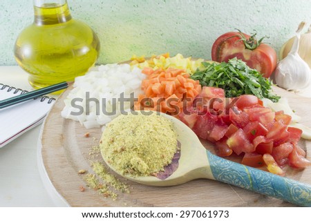 Sliced vegetables and spice in a wooden spoon ready for cooking a healthy meal