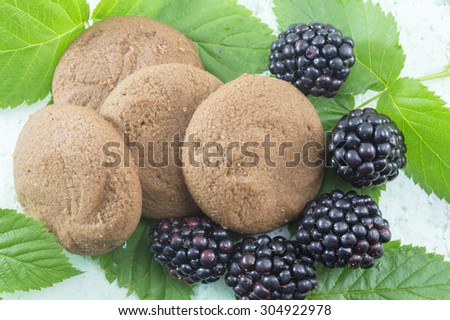 Integral biscuits and fresh blackberries on blackberry leaves. Healthy dessert