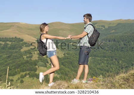 Happy hikers couple in love holding hands in the mountains