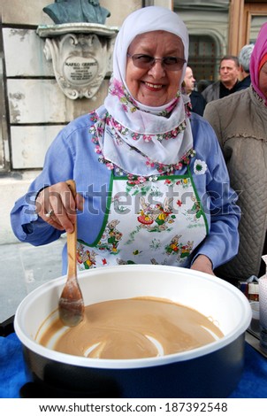 LJUBLJANA, SLOVENIA - APRIL 12, 2014: Bosnian woman cooks halva at Festival of Bosnian Food and Presentation of Bosnian Rug organized by Women\'s Association Zemzem on Stritar street in old town.