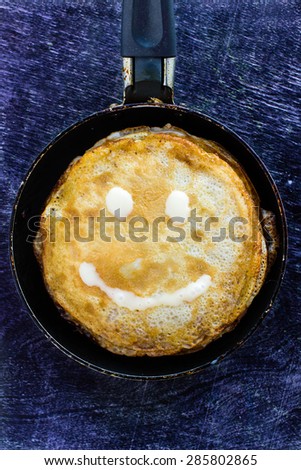 Pancakes on pan on wooden background.  Creative smile. Funny breakfast.