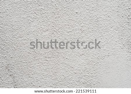 Close-up to an aged wall with irregular sprayed plaster