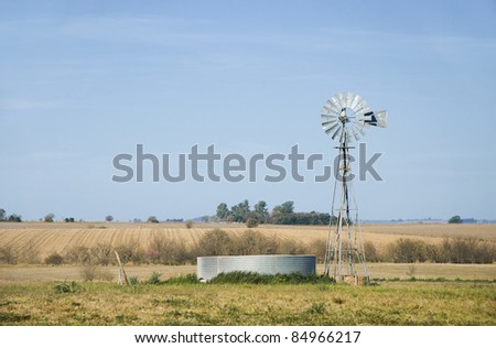 A windmill for pumping water and a metallic tank in the country. Province of Entre Rios, Argentina.