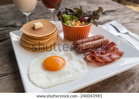 English breakfast with fried eggs, bacon, sausages and salad