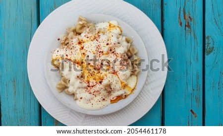 Traditional Turkish manti. Famous Turkish food mantı on the wooden table. Close up of handmade manti. Traditional Turkish dumplings. Dumplings with meat onion and spice Turkish dumplings recipe