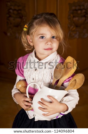 girl holds a jug with kitchen devices