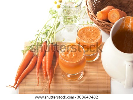 Glass of carrot juice and fresh carrots isolated on white