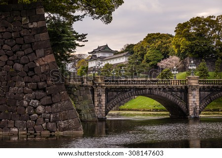 Tokyo - April 11: The Imperial Palace in Tokyo, Japan; with the stone wall that surrounds its grounds in the foreground. Photograph shot on April 11, 2015.