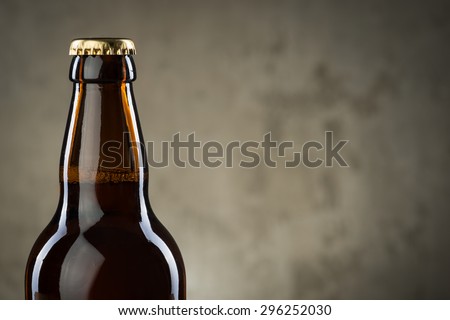 One ice cold beer bottles in a row over the grey concrete wall background