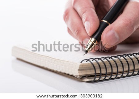 Man writing a note with black ball pen in his hand over the white background, isolated