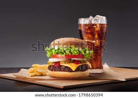 burger, fries and coke on the wood table