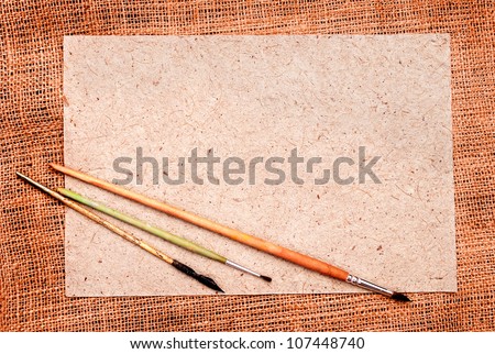 Burlap and paper with brushes background with place for text or drawing