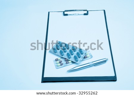 Medical clipboard with pen and pills