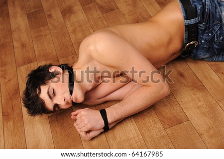 Attractive binding man laying on a floor, sexual role games.