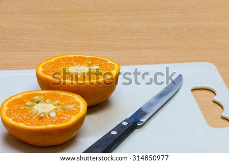 pieces of orange, a little knife cut orange to two pieces on the chopping block