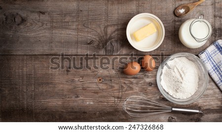 rough background with the ingredients for a cake (butter, egg, milk , flour)