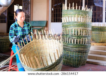 Vinh Long city, Vietnam - 06 May 02, 2015: Unknown, An Asian woman weaving handicraft basket from bamboo. The fruit trader on floating market in the Mekong Delta will need the baskets like these