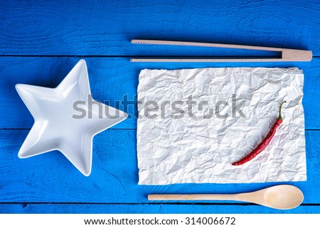 Kitchenware and red chili pepper on a sheet of paper