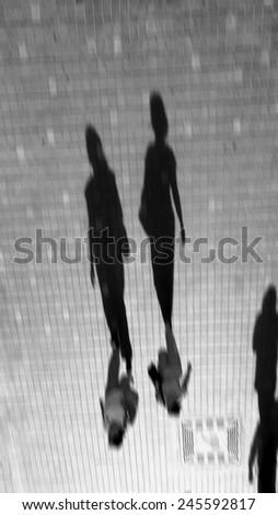 Blurred image abstract human shadow walk in the city. black and white design for background.