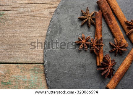 Cinnamon sticks and star anise on a stone and wooden background