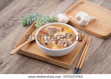 Taiwanese food - Homemade delicious garlic chicken soup in a bowl on dark wooden table background.