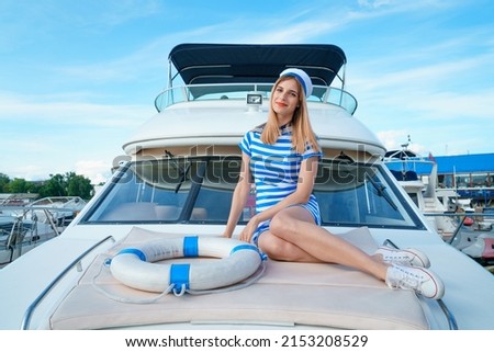 Similar – Foto Bild Attraktive blonde Skipperin, die das schicke Katamaran-Segelboot an einem sonnigen Sommertag auf ruhigem blauen Meerwasser steuert.