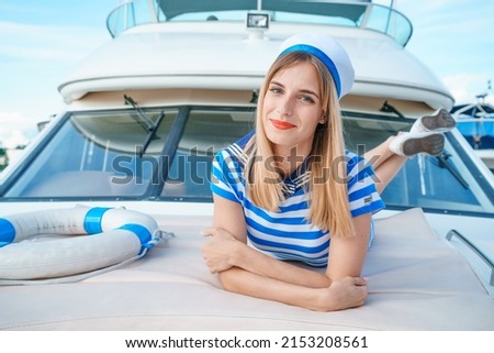 Similar – Foto Bild Attraktive blonde Skipperin, die das schicke Katamaran-Segelboot an einem sonnigen Sommertag auf ruhigem blauen Meerwasser steuert.