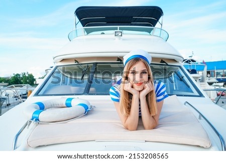 Similar – Foto Bild Attraktive blonde Skipperin, die das schicke Katamaran-Segelboot an einem sonnigen Sommertag auf ruhigem blauen Meerwasser steuert.