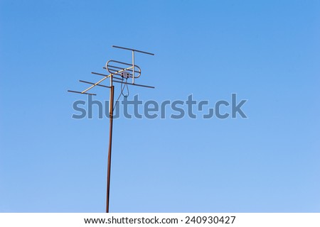 Old TV antenna on clear blue sky background