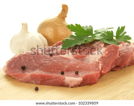 Pieces of raw pork shoulder with onion, garlic and pepper