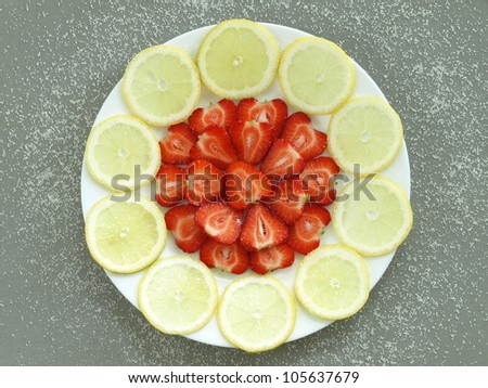 Plate of strawberries and lemon pieces, bird eye view