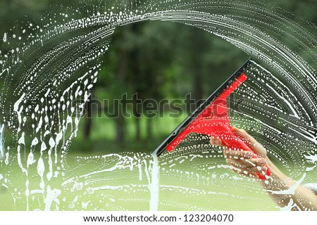 Windows cleaning, glass without smudges red squeegee