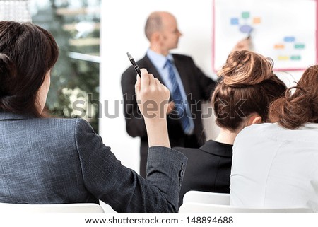 Business person asking a question at a meeting