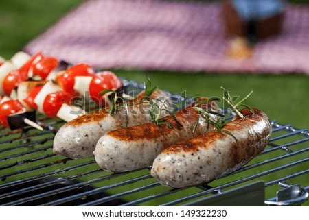 White sausages grilling during a summer barbecue