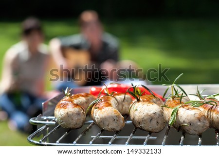Grilling sausages with a music party in the background
