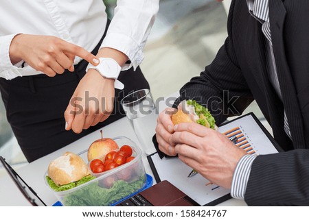 Unhappy manager rushing worker who is having his lunch
