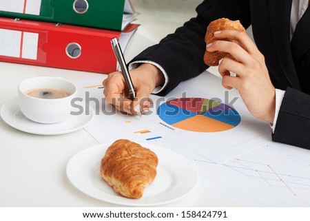 Coffe and croissant at office desk during work
