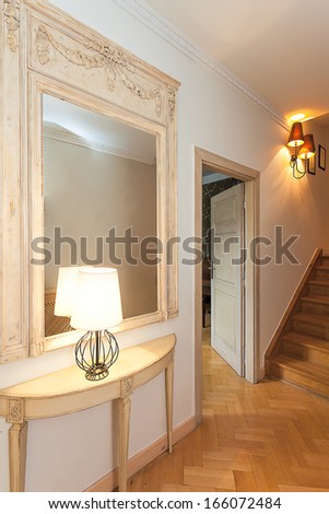 Vintage mansion - a climatic hall with stairs, a mirrors and a lamp