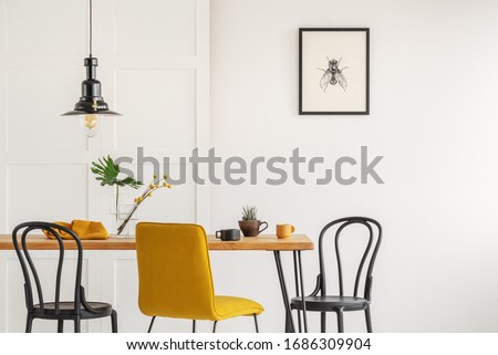 Stylish yellow chair at wooden dining table in trendy interior